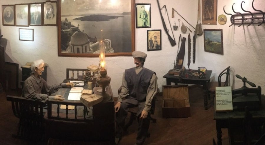 exhibit shows two men discussing by lamplight at 'Koutsoyannopoulos Wine Museum'